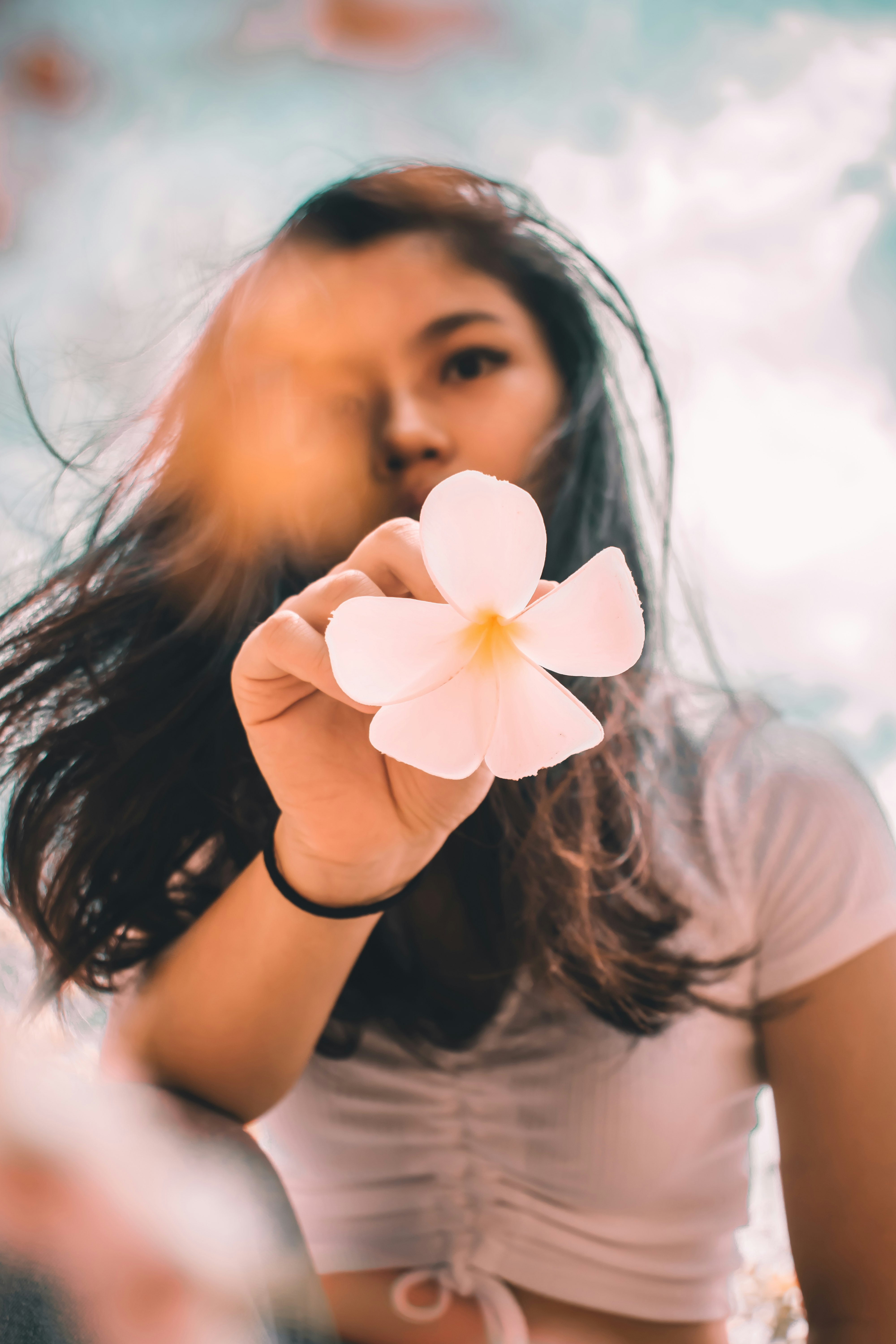 woman in white shirt holding white flower